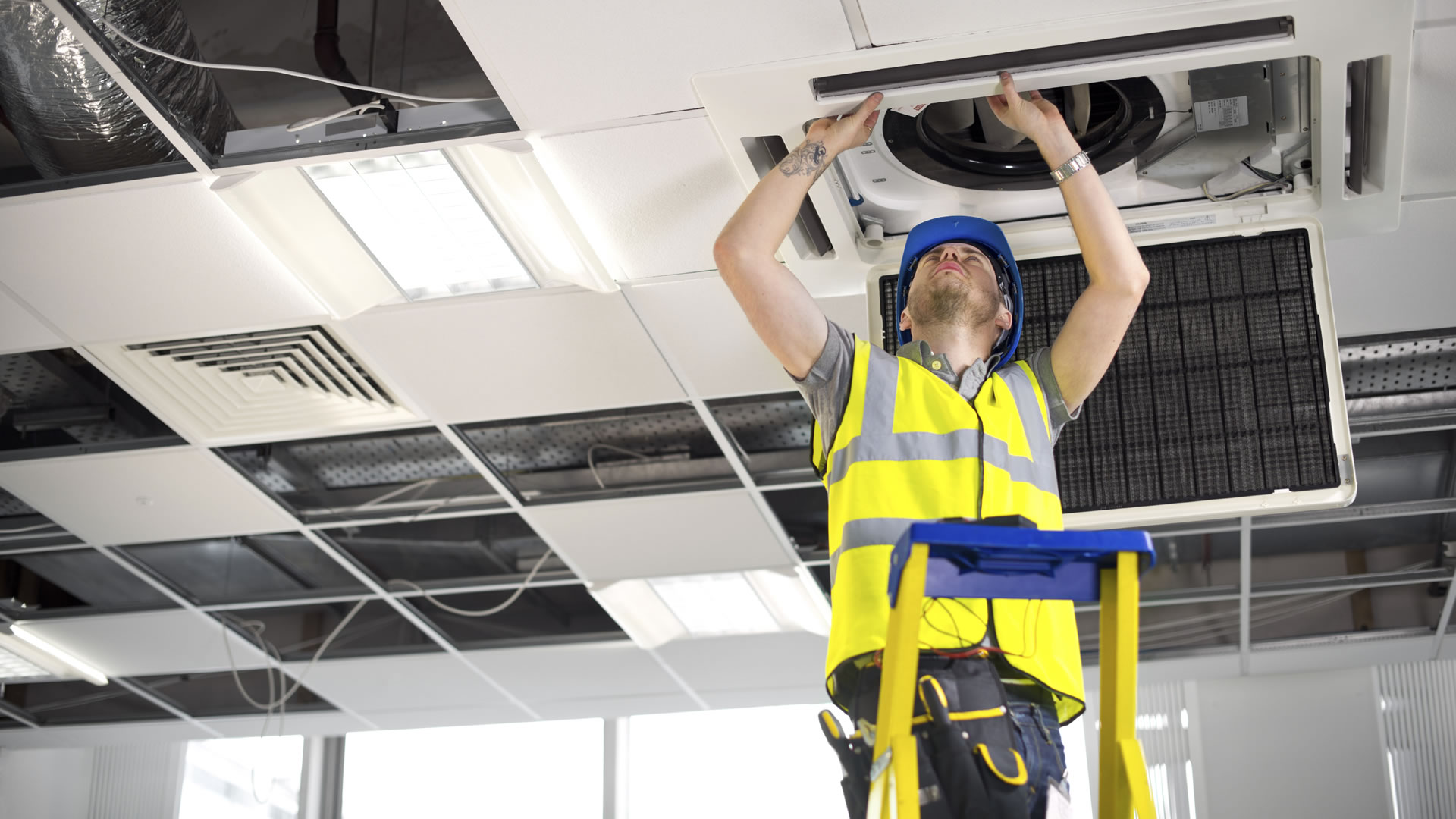Engineer fitting airconditioning unit